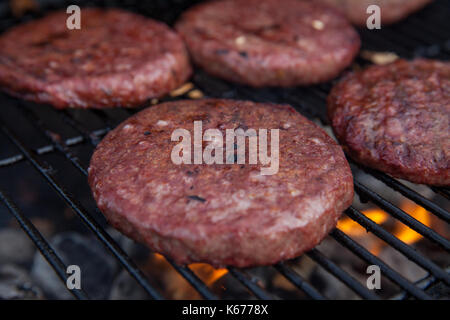 Beef or pork meat barbecue burgers for hamburger prepared grilled on bbq fire flame grill Stock Photo