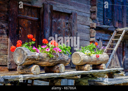 Typical flower decoration at on of the old wooden houses of the mountain town Stock Photo