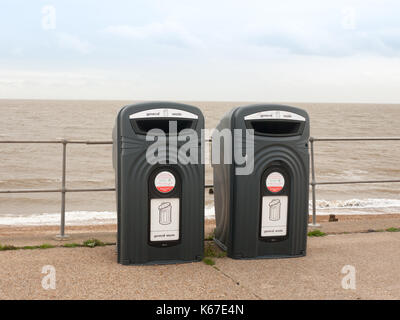 two black recycling bins on the sea front beach for glass; England; UK Stock Photo