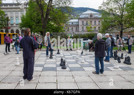 SARAJEVO, BOSNIA AND HERZEGOVINA - APRIL 15, 2017: Old men playing a giant chess game in the city center of Sarajevo, capital city of Bosnia. This che Stock Photo