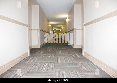 a long empty beige hallway in an apartment building Stock Photo