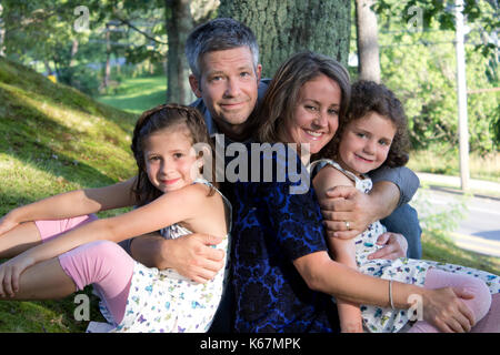 father, mother and their two beautiful daughters in a portrait outside Stock Photo