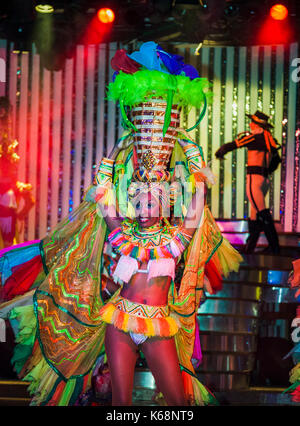 Local exotic dancers performing live on stage in flamboyant colourful costumes in a cabaret show for tourists in a nightclub in Havana, Cuba Stock Photo