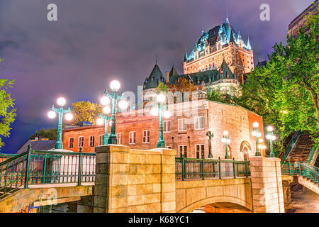 Quebec City, Canada - May 30, 2017: View of Porte Prescott bridge and Chateau Frontenac by old town street Cote de la Montagne with stone buildings at Stock Photo