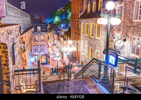 Quebec City, Canada - May 30, 2017: Escalier Casse-Cour on lower old town street Rue du Petit Champlain with restaurants during rainy night or twiligh Stock Photo