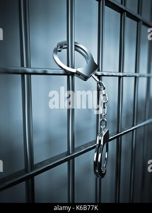 Handcuffs attached to metal prison bars.3D illustration. Stock Photo