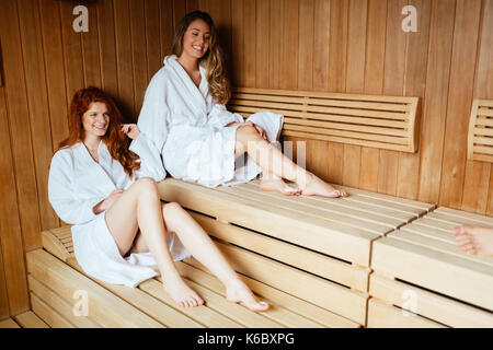 Beautiful women enjoying sauna treatment in bathrobes Stock Photo - Alamy