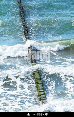 View from above down to row of groynes in waves of baltic sea View from above down to row of groynes in waves of baltic sea
