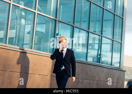 Builder On construction Site Using Mobile Phone Stock Photo
