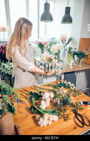 Small business. Male florist unfocused in flower shop. Floral design studio, making decorations and arrangements. Flowers delivery, creating order Stock Photo