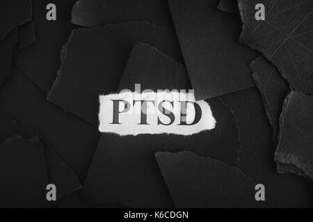 Post Traumatic Stress Disorder. Torn pieces of black paper and words Post Traumatic Stress Disorder. Concept Image. Black and White. Closeup. Stock Photo