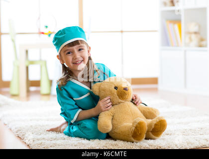 Smiling kid girl pretending she is a doctor in hospital Stock Photo