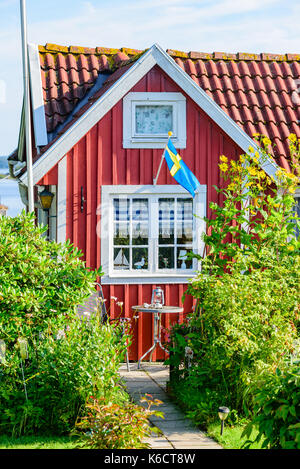 Karlskrona, Sweden - August 28, 2017: Travel documentary of city gardens. Detail of cabin gable with lane and shrubbery surrounding it. Lantern on tab Stock Photo