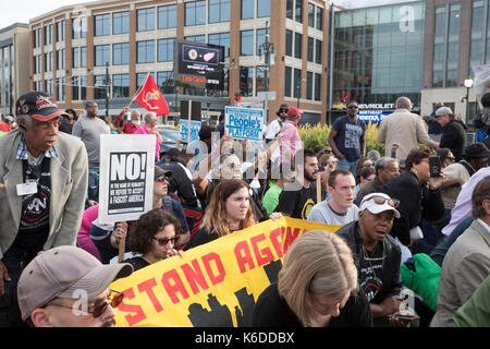 Detroit, Michigan USA - 12 September 2017 - As the new Little Caesars sports/concert arena opened, people protested the selection of Kid Rock for the arena's inaugural concert. The singer has displayed the Confederate flag at some of his past concerts; protesters felt that was not an appropriate message for the arena, which was partially paid for with taxpayer dollars. During the protest, people knelt in the street while the National Anthem was played, in solidarity with NFL player Colin Kaepernick, who was the target of Kid Rock profanity after he protested American racism by refusing to stan Stock Photo