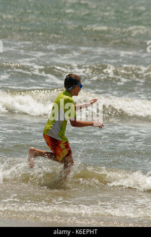 BOY PLAYING IN WAVES IN GULF OF MEXICO, BOLIVAR PENINSULA, TEXAS Stock Photo