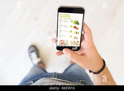 close up of male hand using online supermarket app smart phone Stock Photo