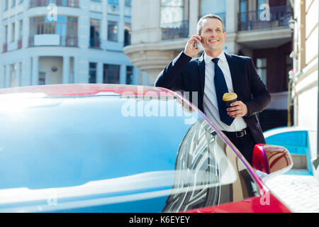 Cheerful nice businessman holding a cup of coffee Stock Photo