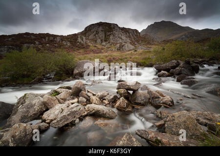 Rhaeadr Ogwen (Ogwen Falls) in the Nant Ffrancon valley, with Tyrfan in the distance, in Snowdonia National Park, Wales, UK. Stock Photo