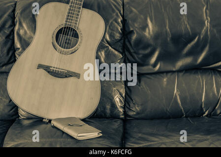 Song writing at home on acoustic guitar. Stock Photo