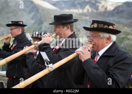 Four traditionally dressed locals playing alphorn, Zermatt, Valais, Switzerland Stock Photo