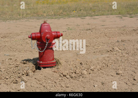 Red fire hydrant in empty field on bulldozed shopping center under new development and revitalization Stock Photo