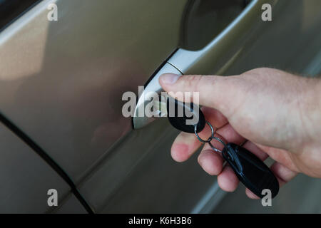 man's hand opens the car door with a key. Stock Photo