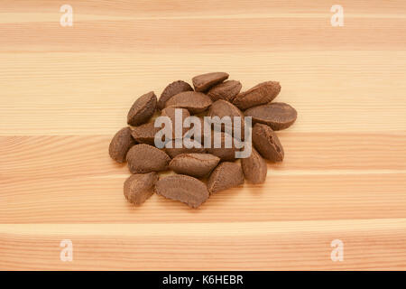 Brazil nuts in shells on a wooden background, pine wood grain Stock Photo