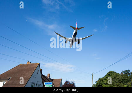 Low flying jet flying over residential housing approaching Heathrow airport Stock Photo