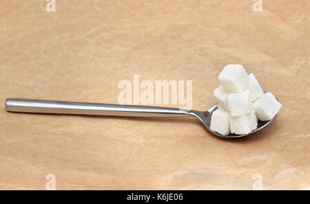 Spoon full with white sugar cubes pile Stock Photo