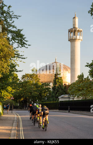 London, England, UK - August 30, 2016: Cyclists pass the London Central Mosque on Regents Park's Outer Circle Road. Stock Photo