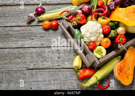 Raw organic set of fresh vegetables in wooded box background. Autumn harvest from the garden Stock Photo