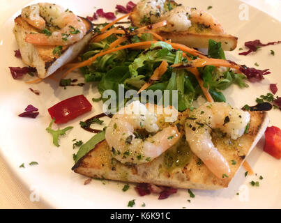 Italian Starter - Bruschetta Con Gamberetti - Marinated tiger prawns with garlic, basil and olive oil on toasted bread Stock Photo