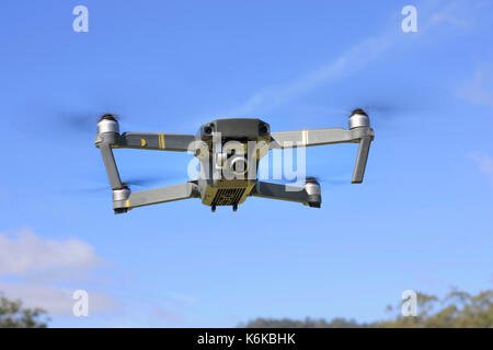 Drone quadcopter with digital camera in flight with blue sky Stock Photo
