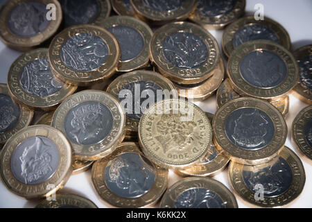 An old style pound coin amid a pile of new 2017 pound coins Stock Photo