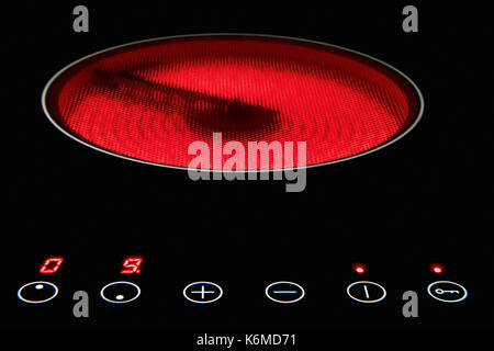 Modern induction cooker with control buttons. The electric hob closeup. Stove top panel at modern kitchen. Stock Photo