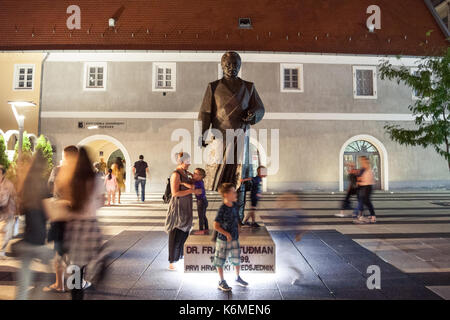 OSIJEK, CROATIA - AUGUST 25, 2017: Children playing at night in front of a statue of Franjo Tudman. Franjo Tudjman was the first president of Croatia, Stock Photo