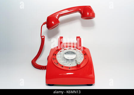 Retro rotary dial phone on call with no body, hang up by hollow man Stock Photo