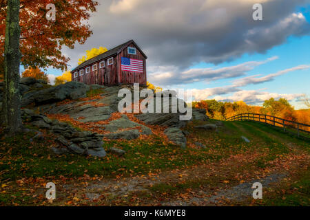 USA Patriotic Rustic Barn - This red rustic barn stands tall on granite and proudly displays the United States of America Flag. It is part of what makes up the Greyledge Farm in Roxbury, Connecticut. Stock Photo