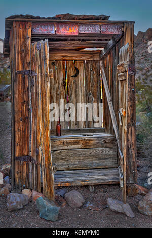 Western Outhouse -  Rustic wooden outhouse outhouse with an empty bottle of bear inside and old Nevada license plates  on the outside. Stock Photo