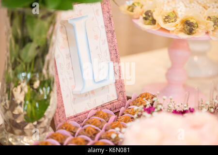 Horizontal picture of letter L in a picture frames and milk candy dessert for woman party Stock Photo