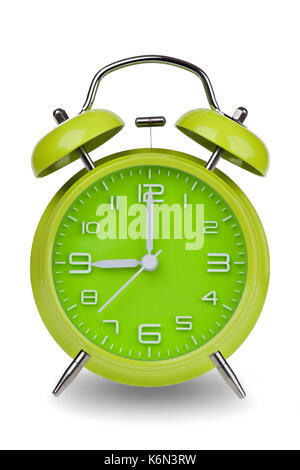 Green alarm clock with the hands at 9 am or pm isolated on a white background with a clipping path. One of a set of 12 images showing the top of the h Stock Photo