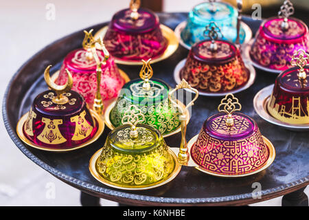 Stack of handmade multicolor Turkish dishes on the market. Vintage plates on round table Stock Photo