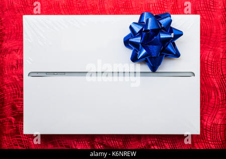 tablet in box for gift on red gift wrap Stock Photo