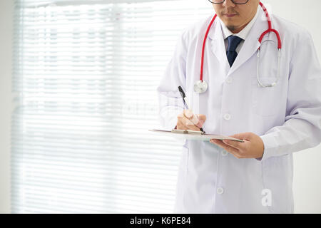 Doctor with a stethoscope and taking notes with bright background . Stock Photo