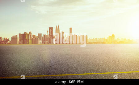 View of the empty asphalt road with city skyline background  . Sunset sunrise scene . Stock Photo