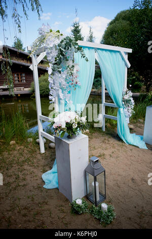 Wedding Arch of turquoise color on background lake Stock Photo