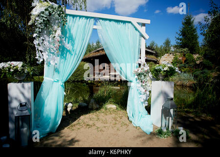 Wedding Arch of turquoise color on background lake Stock Photo