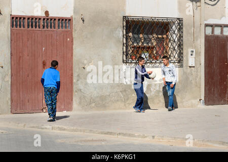 Essaouira, Morocco - December 31, 2016: Children playing with ball on the street in medina Stock Photo