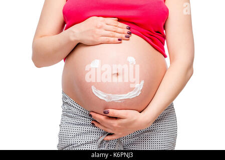 pregnant woman touches the stomach on which is painted a smiling face Stock Photo