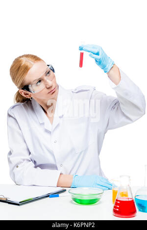 a concentrated laboratory assistant wearing glasses and gloves makes experiments with liquids in test tubes Stock Photo